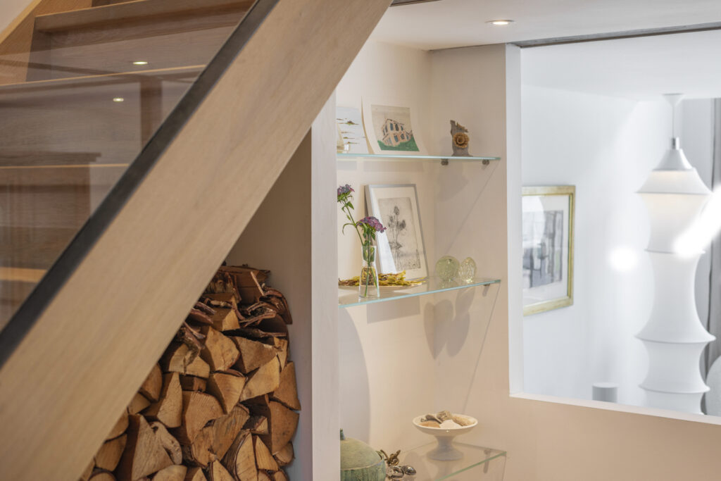 Modern interior with shelves and firewood under stairs