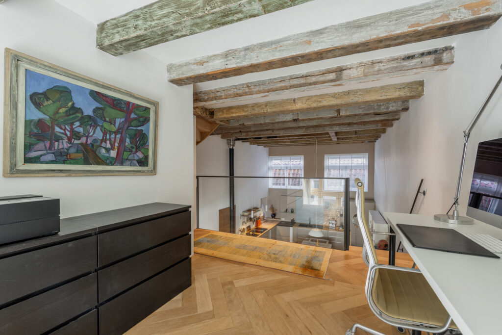 Home office with art and wooden beams.