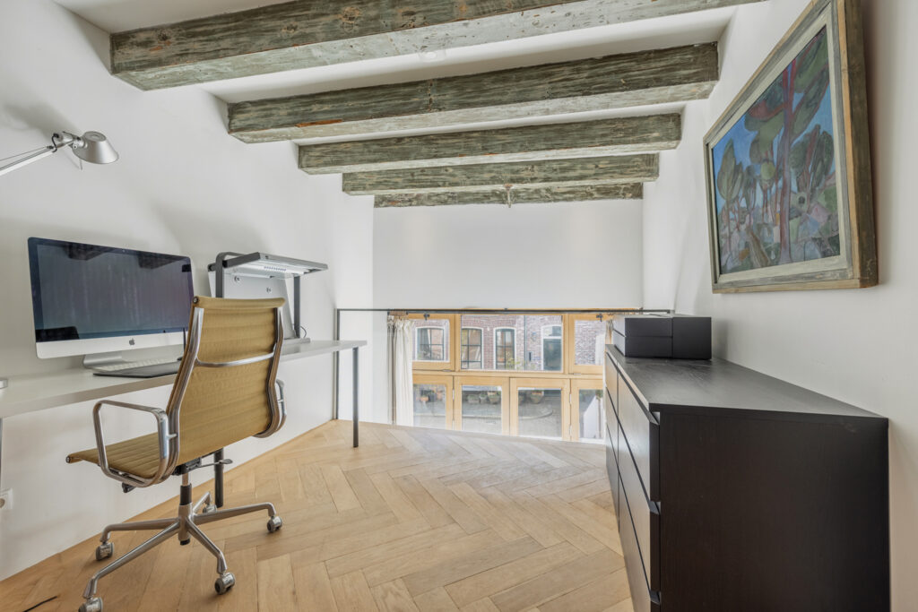 Modern loft office with desk and painting.