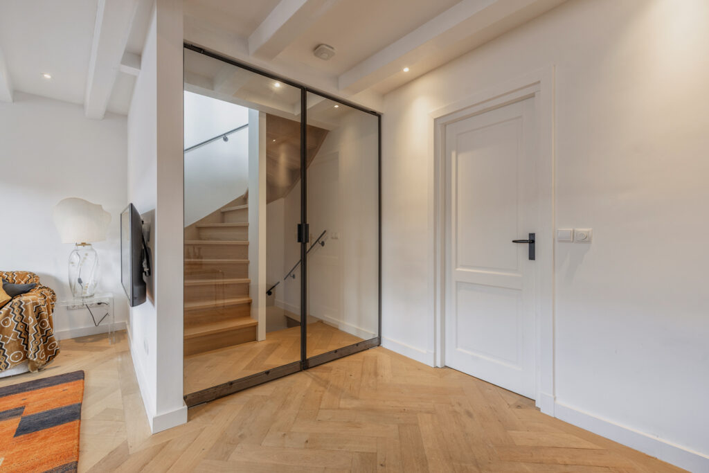 Modern living room with staircase and glass door