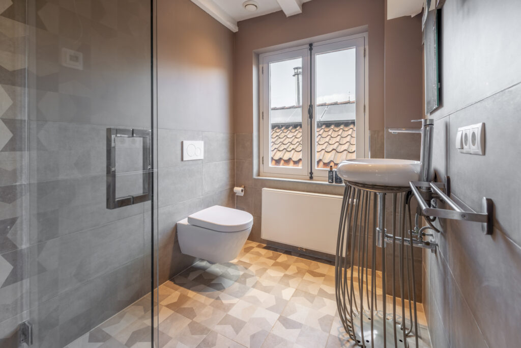 Modern bathroom with sink, toilet, and window.