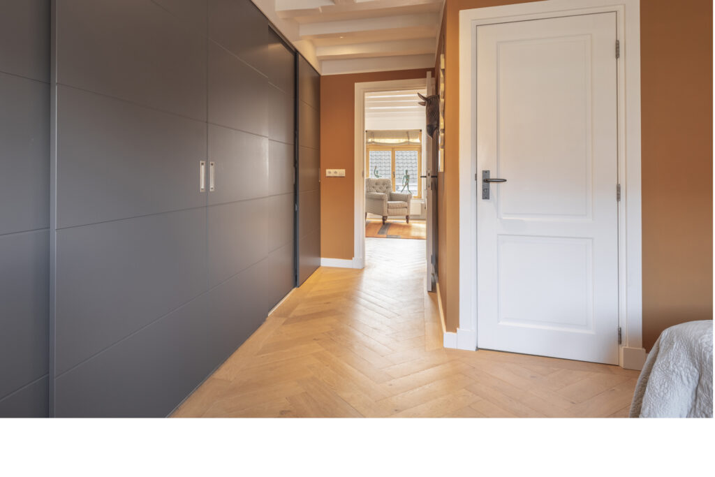 Modern hallway with gray closets and white door.