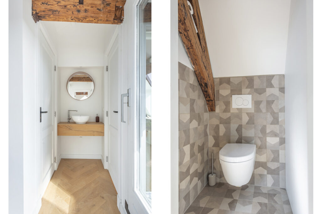 Modern bathroom with geometric tiles and wooden elements.