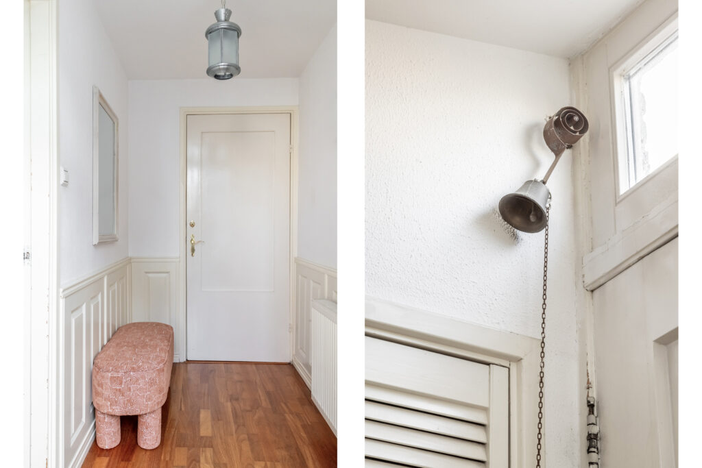 White hallway with wall mirror and pink bench.