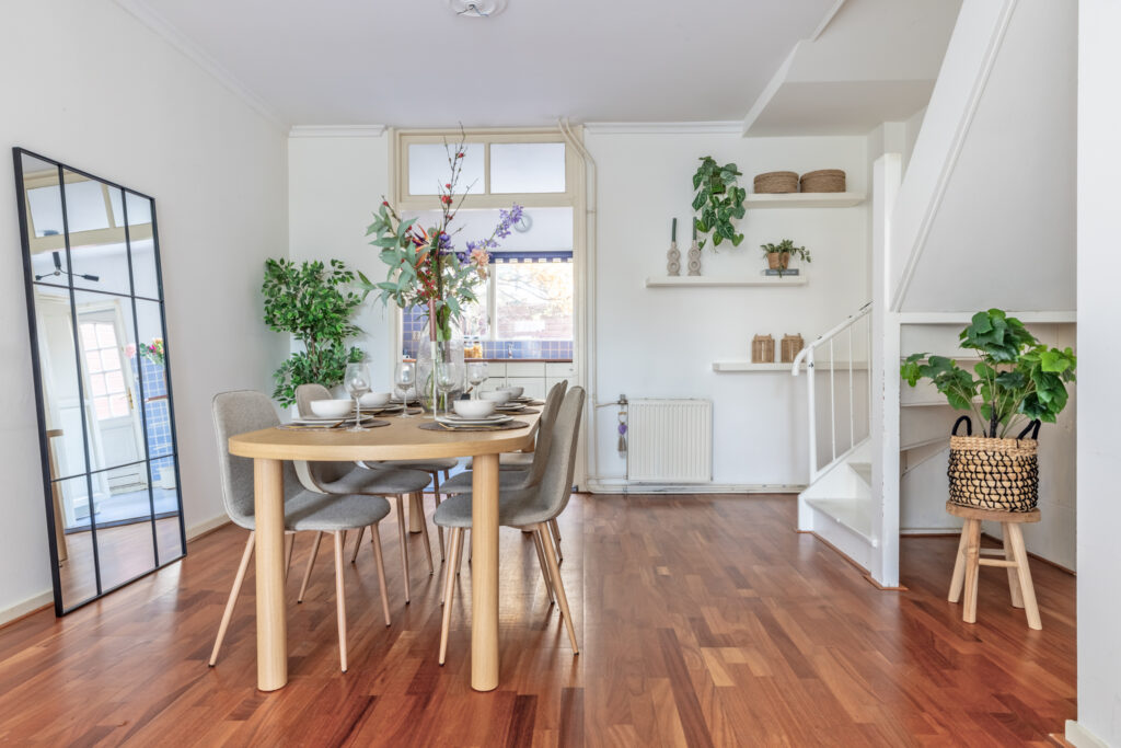 Modern dining room with wooden table and plants.