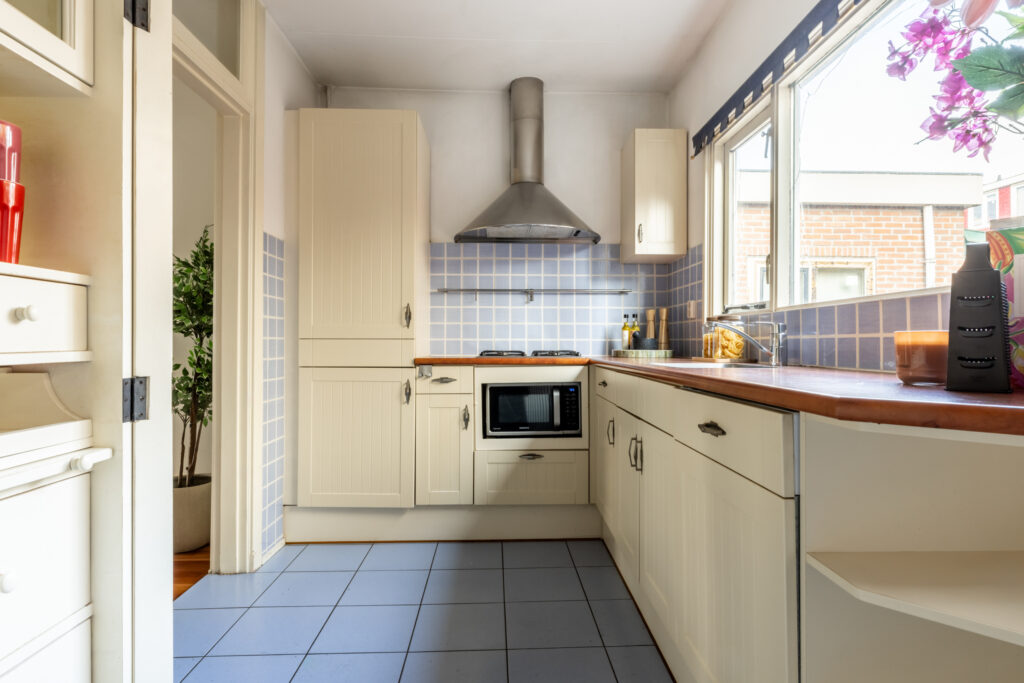 Modern kitchen with white cabinets and appliances.