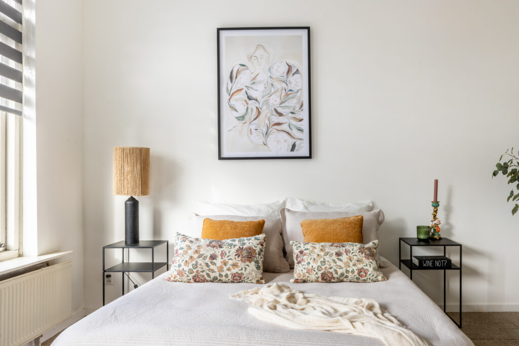 Modern bedroom with decorative pillows and wall art
