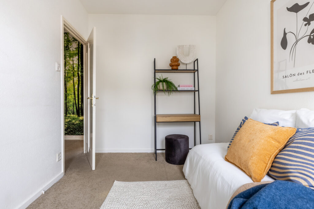 Cozy bedroom with open door and wall art.