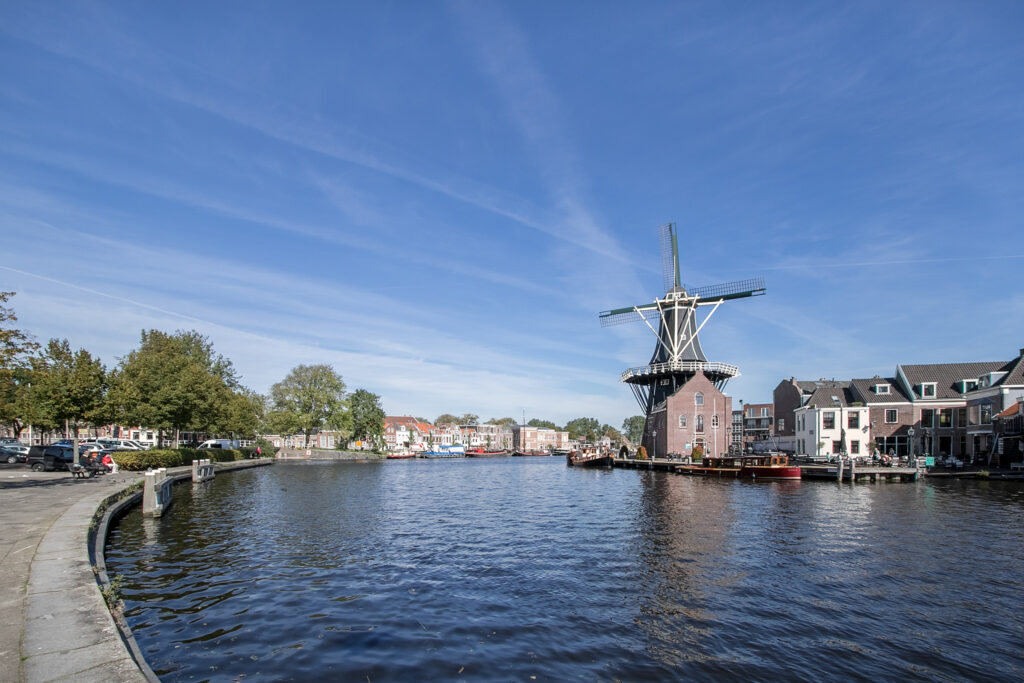 Historic windmill by a riverside in the Netherlands.
