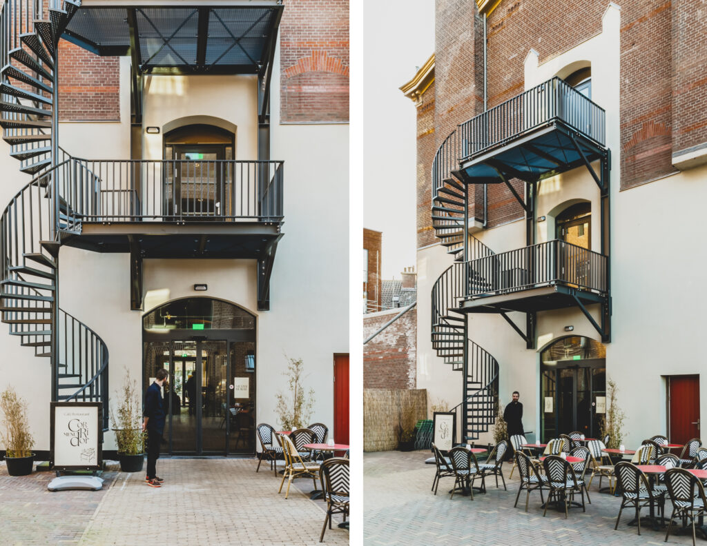Brick building with spiral staircase and outdoor cafe.