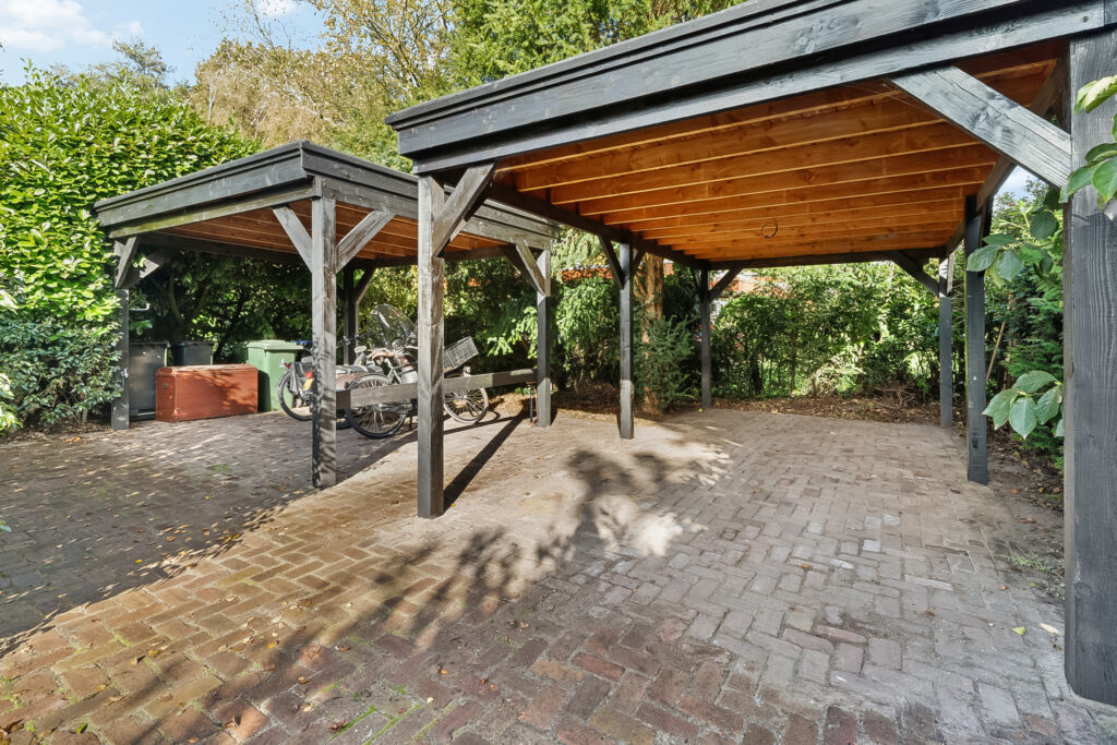Wooden carport with bicycles and greenery