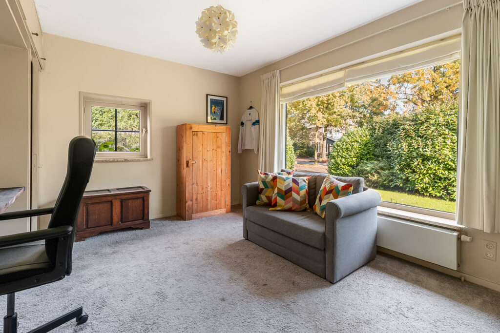 Cozy room with sofa, desk, and window view.