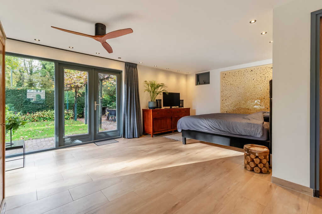 Spacious bedroom with large windows and elegant decor.