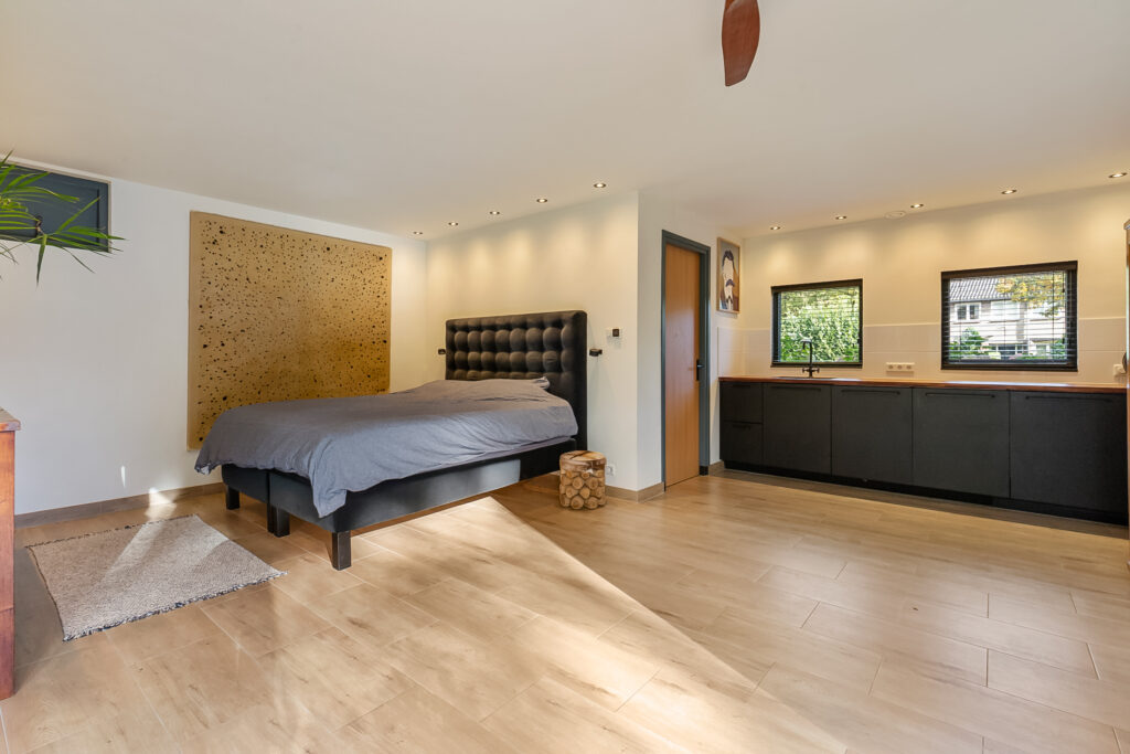 Spacious modern bedroom with large windows and bed.