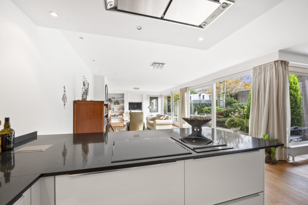 Modern kitchen and living room with garden view.