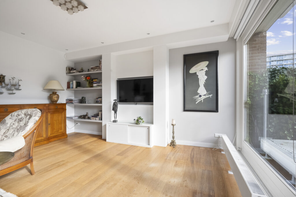 Modern living room with art and large window.