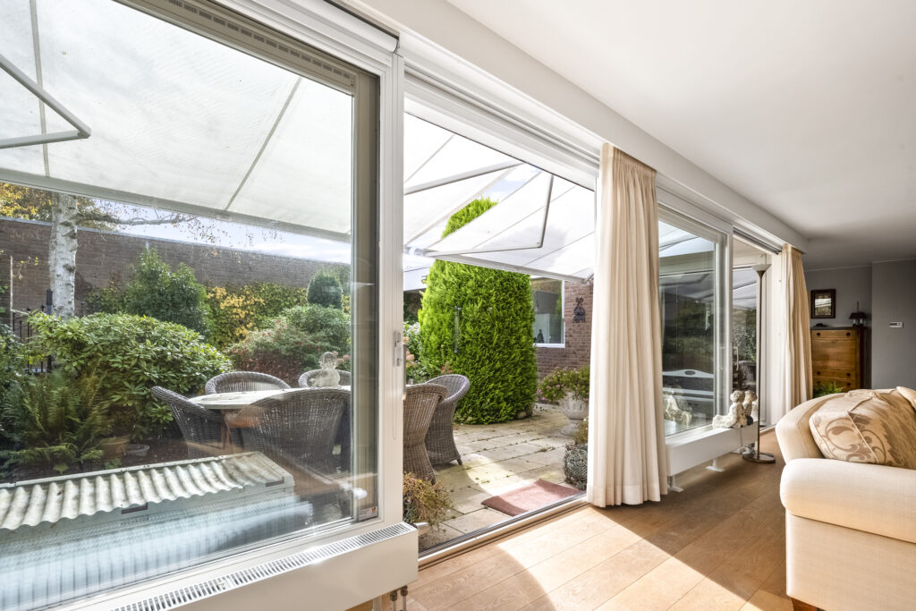Sunny patio garden view through sliding glass doors.