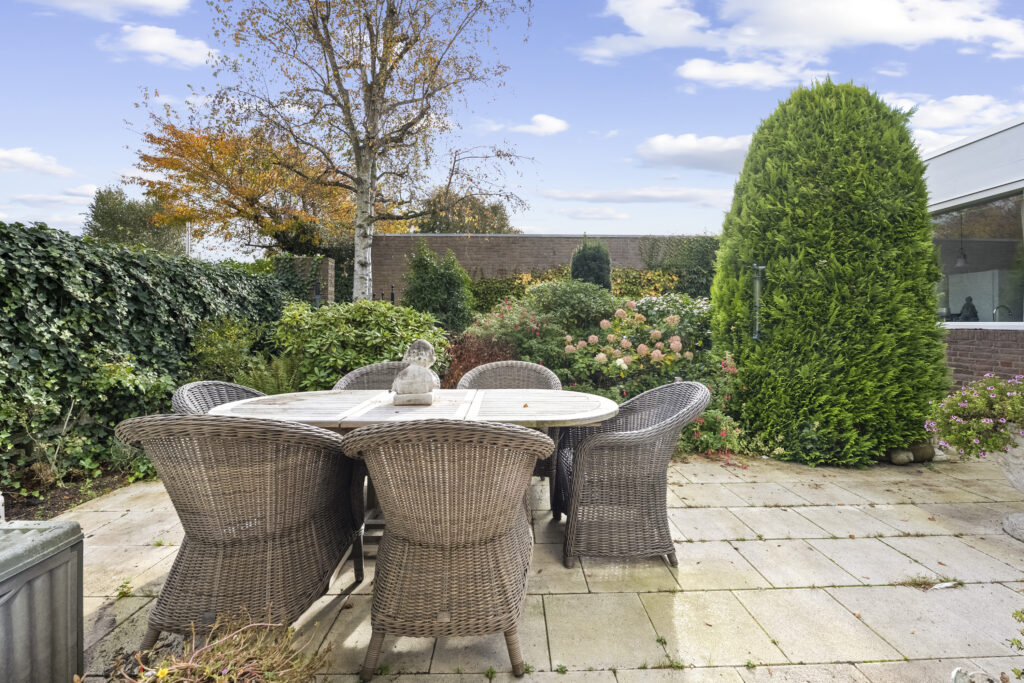 Outdoor patio with wicker chairs and garden