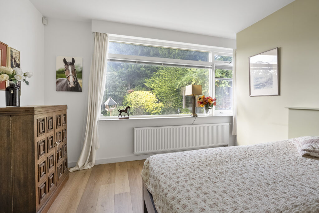 Bright bedroom with large window and garden view.