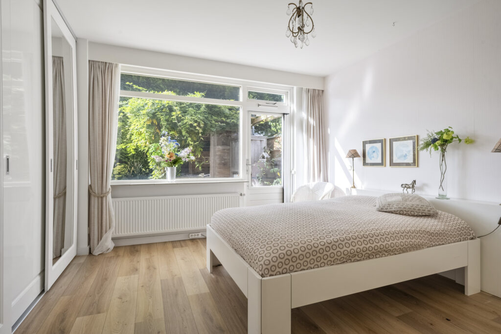 Bright bedroom with large window and modern decor.