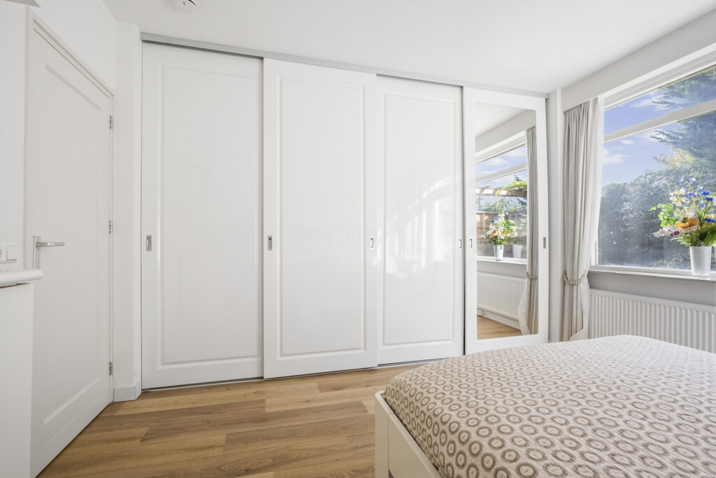 Modern bedroom with white closet and wooden floor
