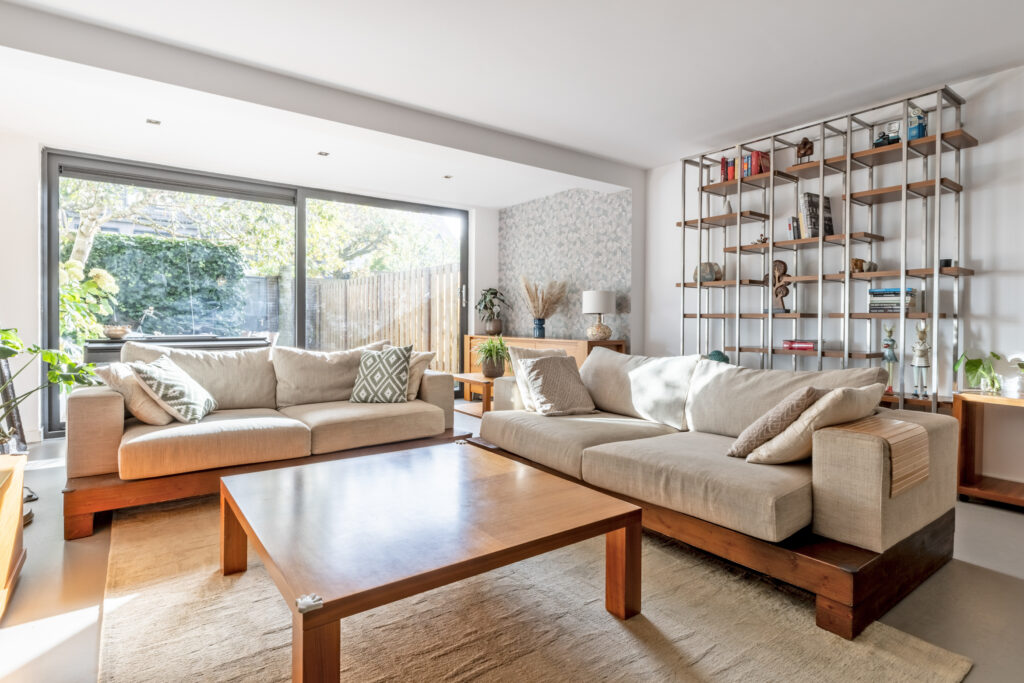 Modern living room with large windows and sofas.