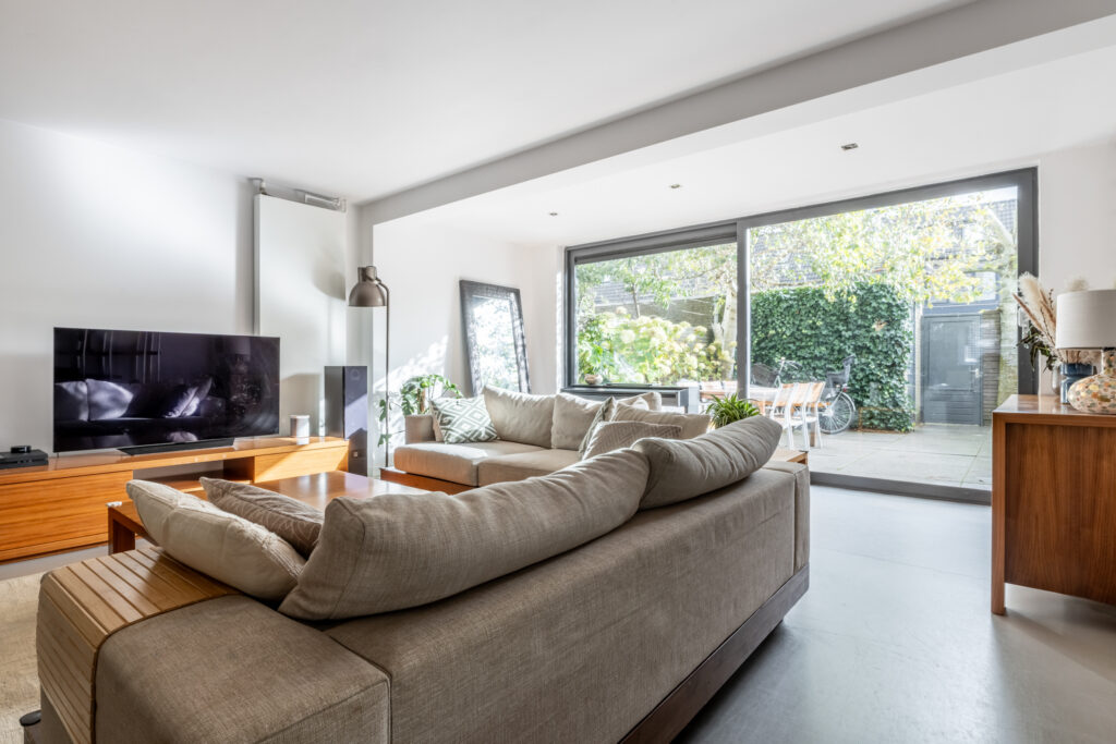 Modern living room with large windows and sofas.
