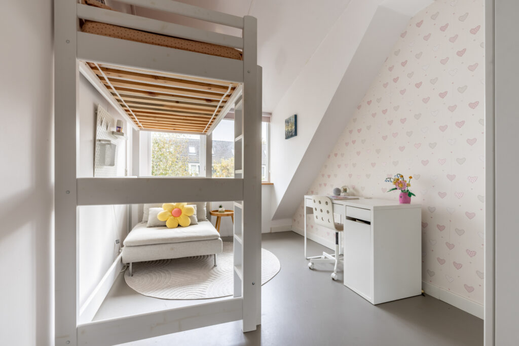 Bright children's bedroom with loft bed and desk.