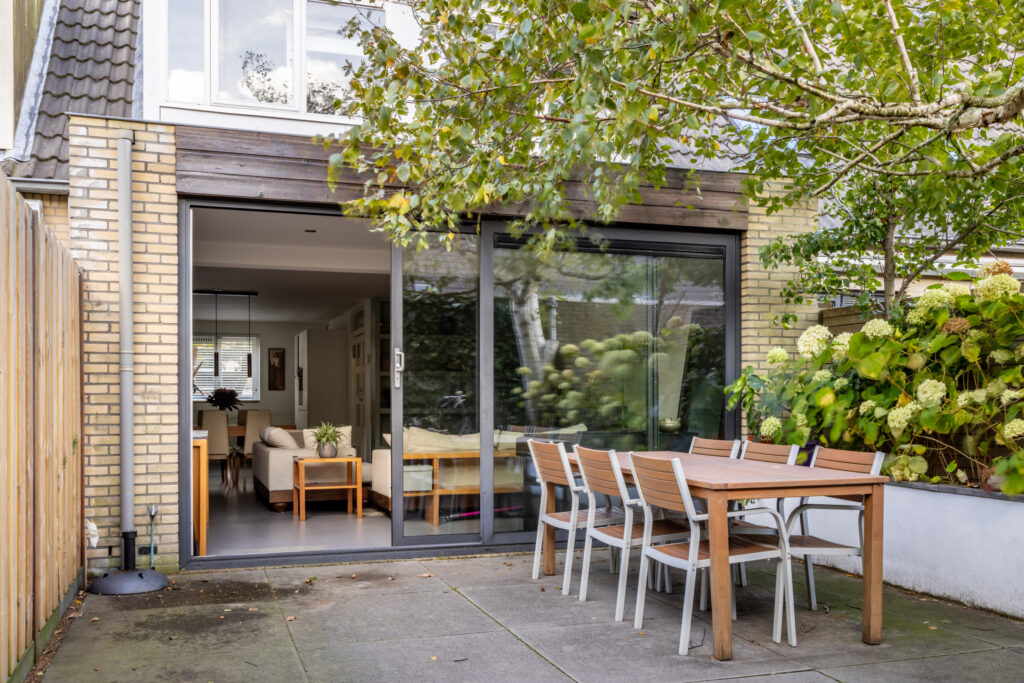 Backyard patio with outdoor dining set and plants.