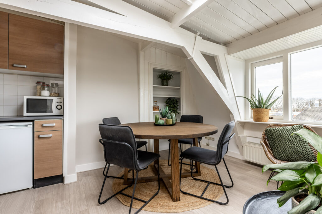Cozy dining area with plants and round table.