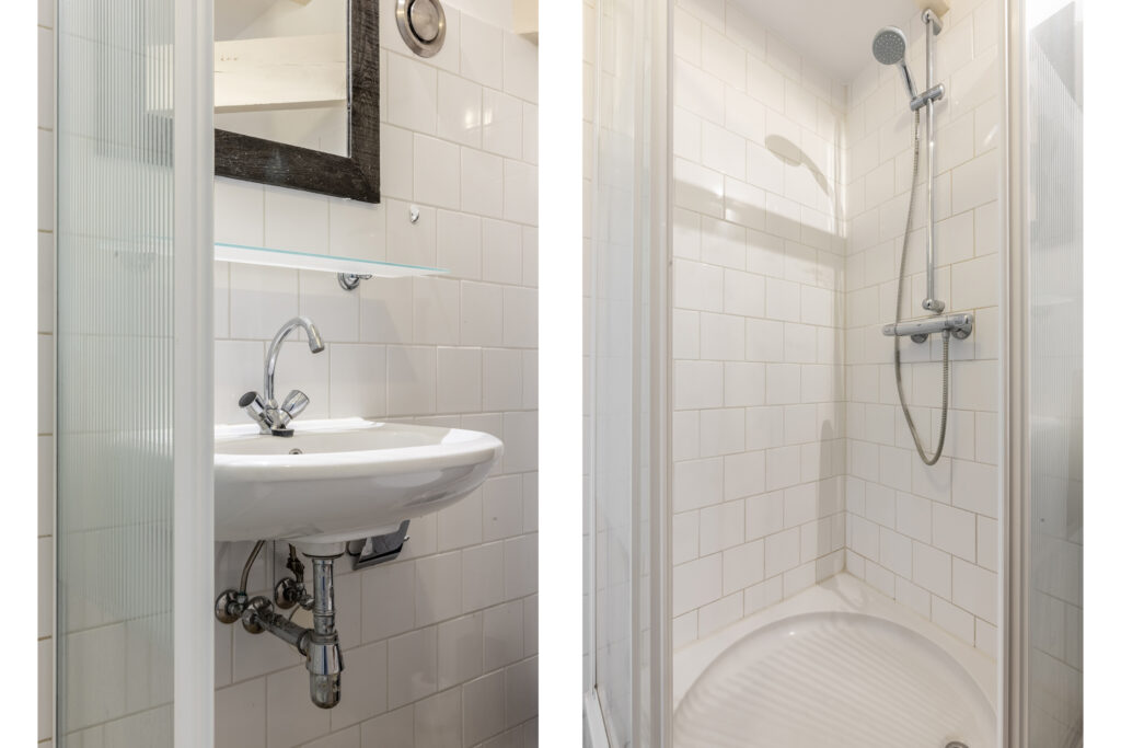 Modern bathroom with white tiled shower and sink.