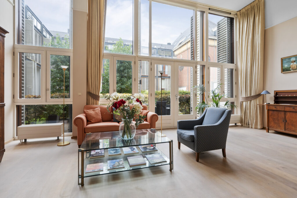 Spacious living room with large windows and cozy seating.
