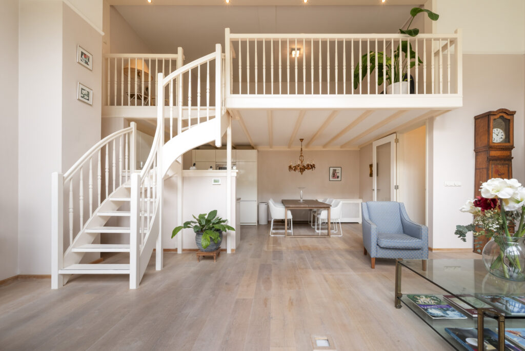 Contemporary living room with staircase and dining area.