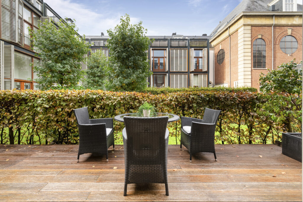 Patio with chairs overlooking garden and building