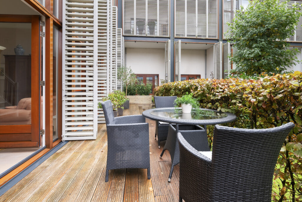 Modern patio with wicker furniture and greenery