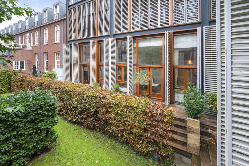 Modern house exterior with large windows and garden.
