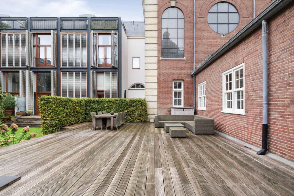 Modern patio with wooden deck and outdoor seating.