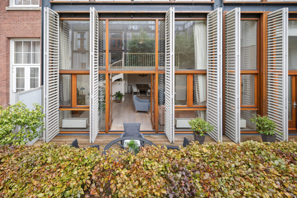 Modern apartment facade with open patio doors.