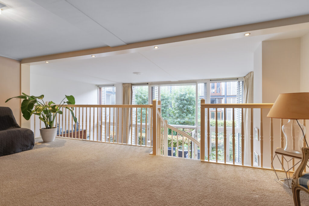 Bright loft area with railing and large windows