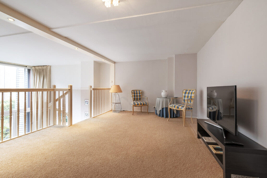 Cozy loft living area with TV and seating.