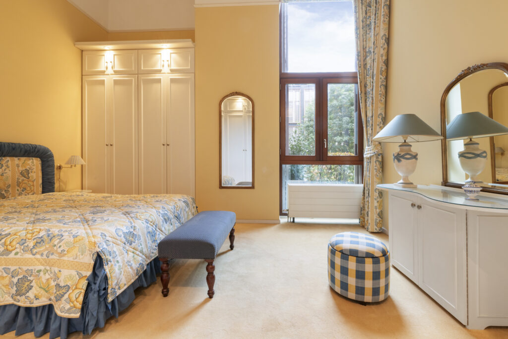 Cozy bedroom with floral bedding and large window.