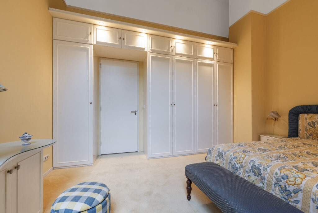 Cozy bedroom with floral bedding and wardrobes.