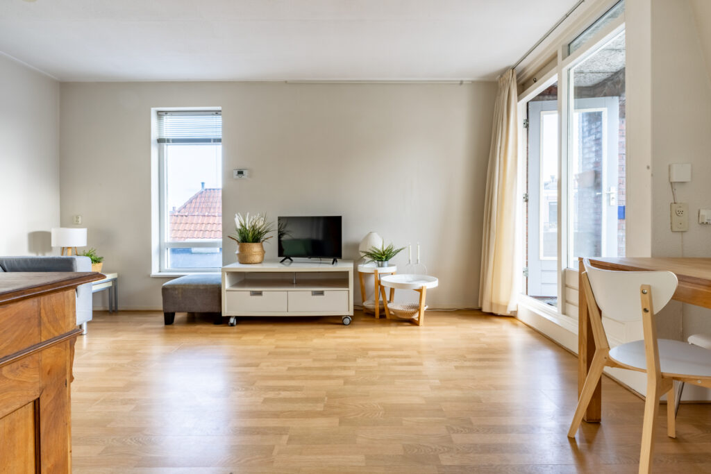 Modern living room with wooden flooring and TV.