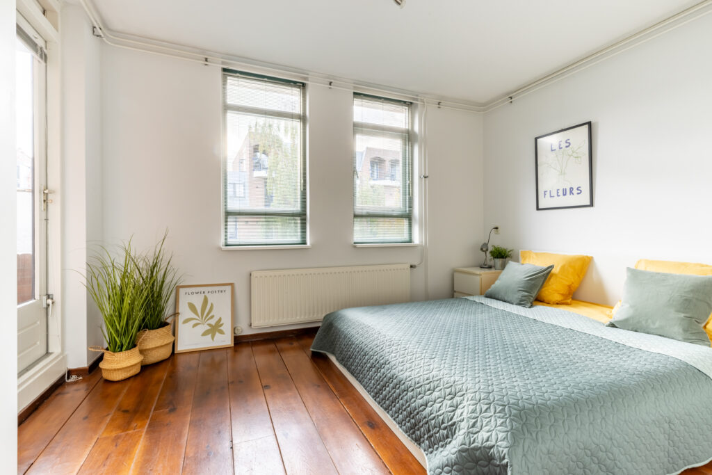 Bright bedroom with plants and wooden floor