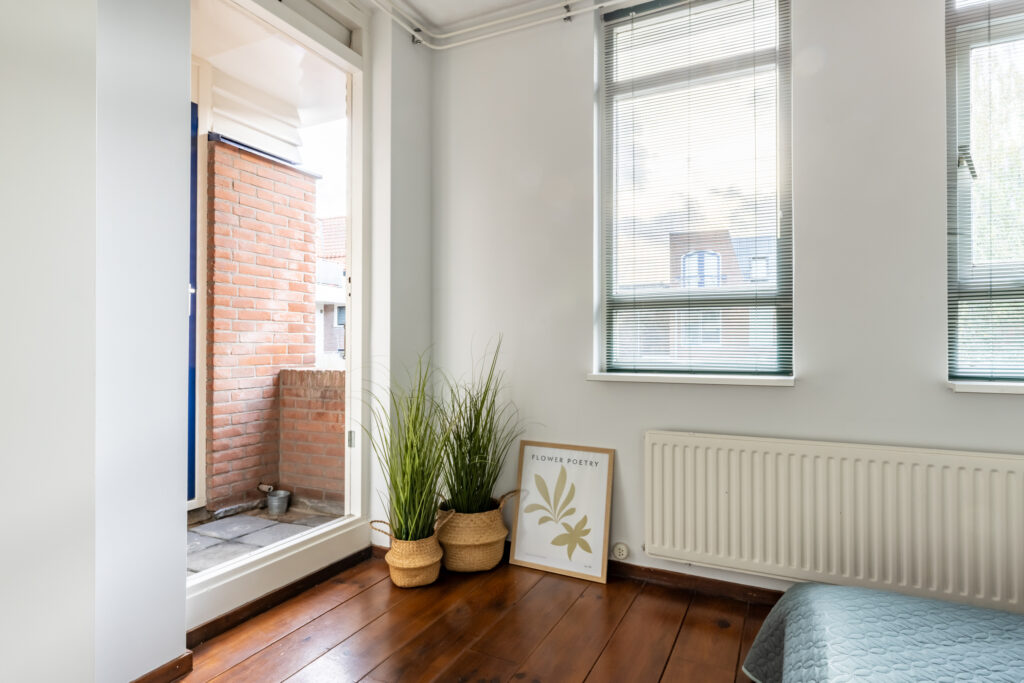 Cozy room with plants and balcony view.