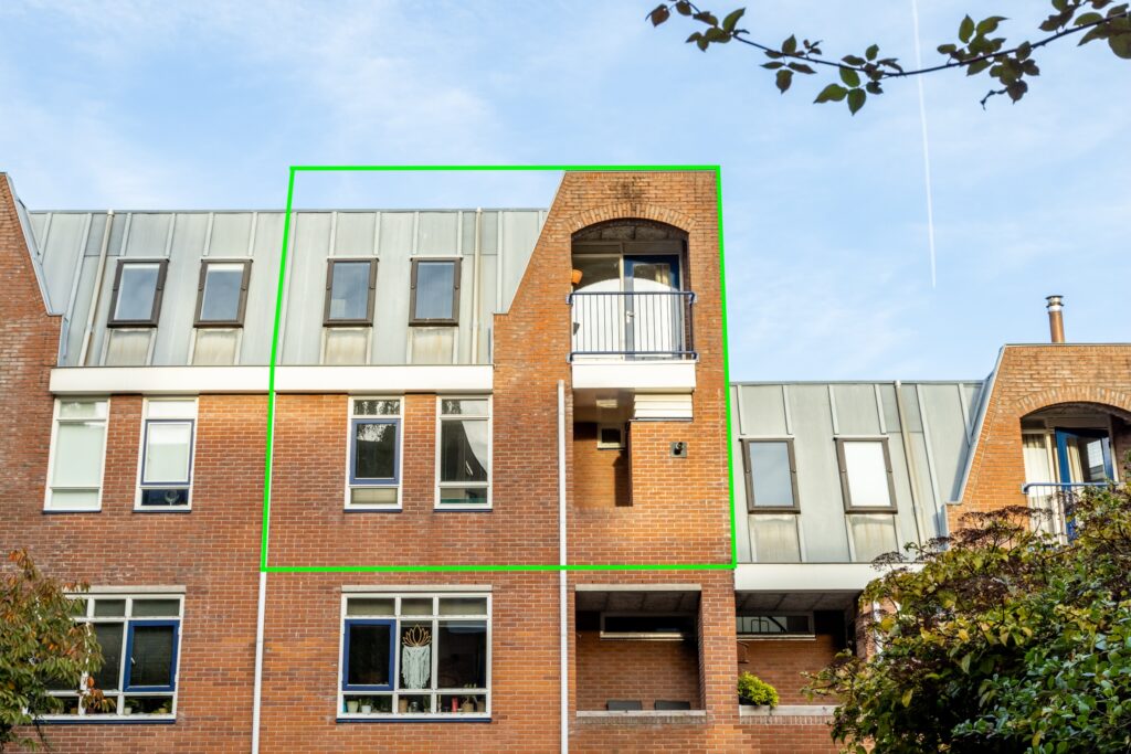 Modern brick townhouse with large windows and balcony.