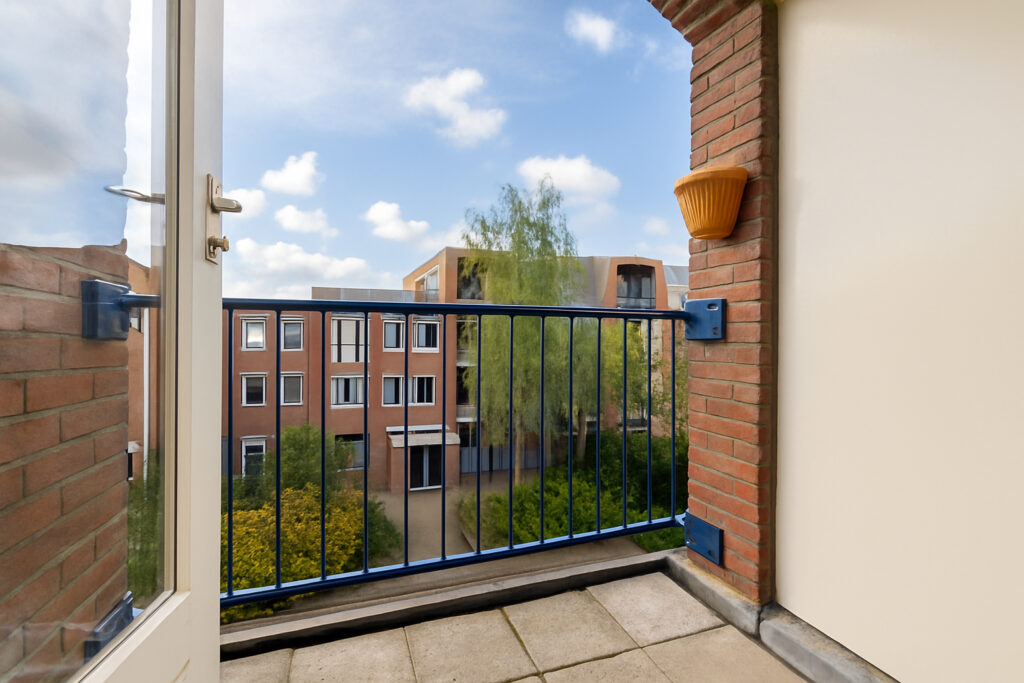 Small balcony with view of residential buildings.