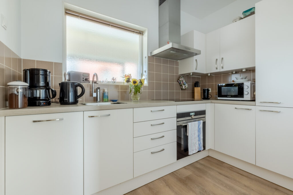 Modern kitchen with appliances and white cabinets.