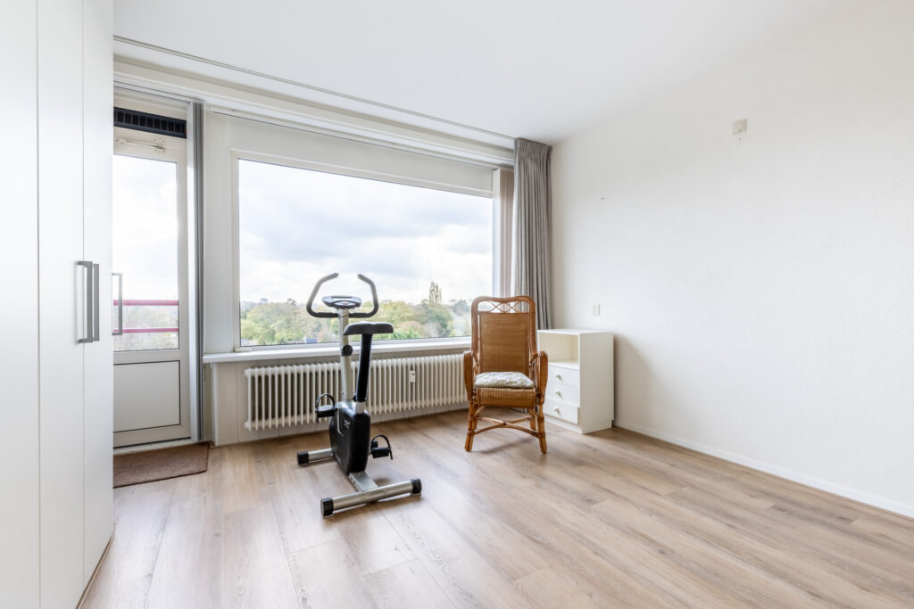 Room with exercise bike and scenic window view.