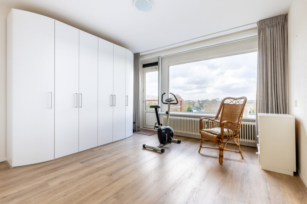 Minimalist room with exercise bike and chair